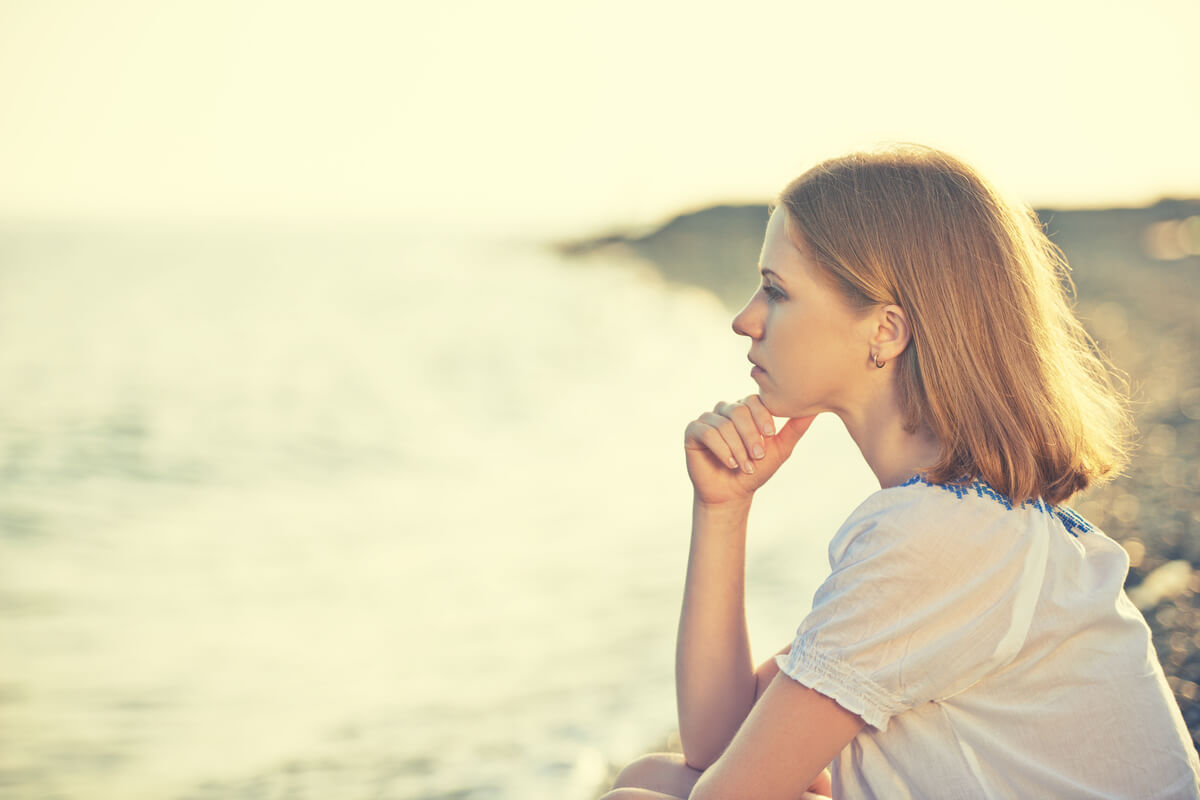 Imagen de mujer pensando mirando al mar